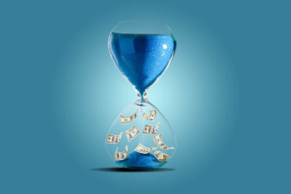 Hourglass with sand and cash